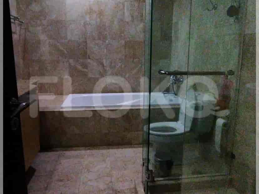 A luxurious bathroom with a bathtub, walk-in shower, and marble walls and floors.