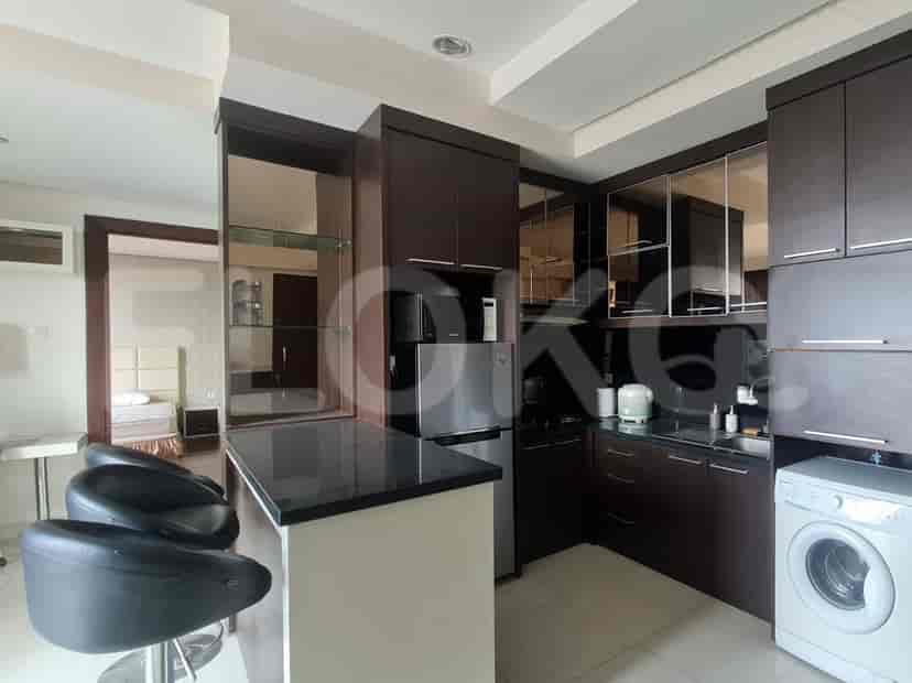 Kitchen and bar area with dark wood cabinets, a bar, and stainless steel appliances.