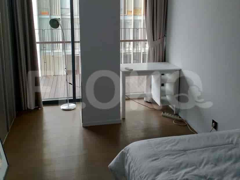 Bedroom with a single bed, desk and a balcony.