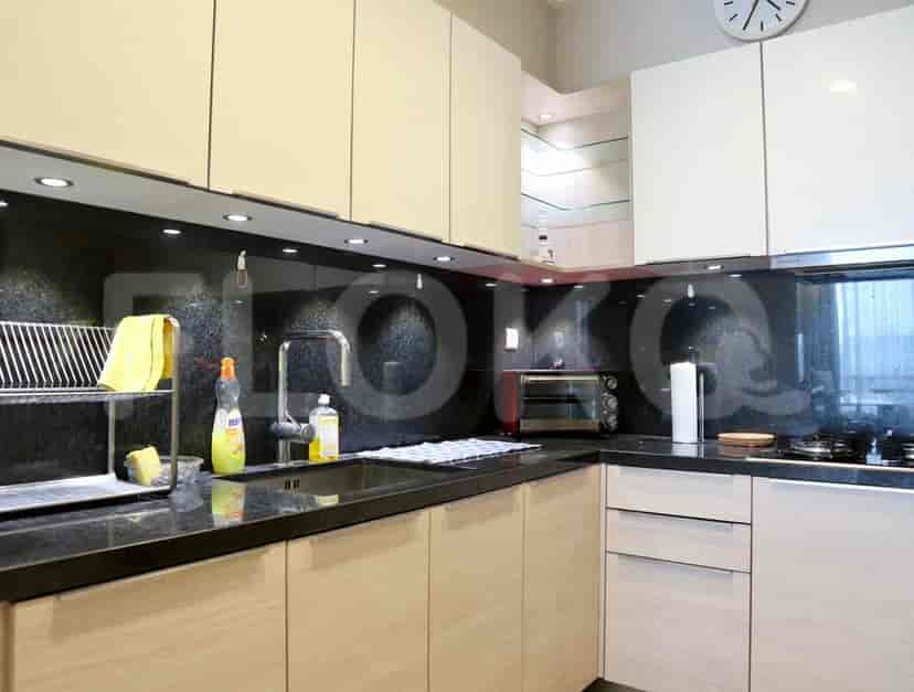 Modern kitchen with black countertops and wooden cabinets.