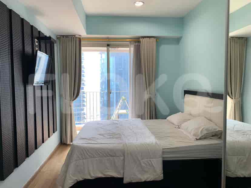 Bedroom with a bed, TV mounted on the wall and access to a balcony.