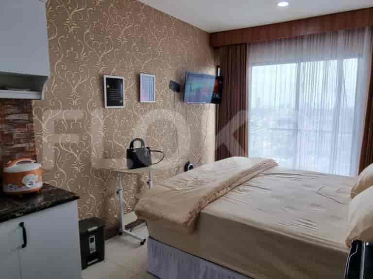 A well-furnished bedroom with a bed, side table, and TV.