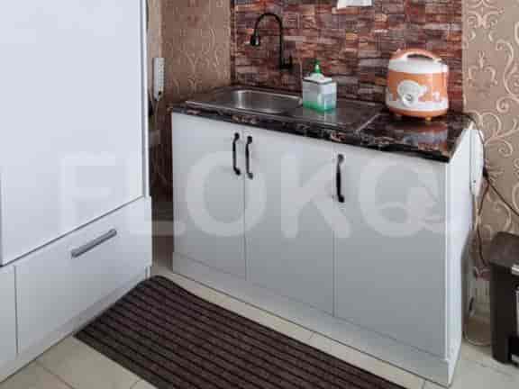 A kitchenette with a sink, cabinets and cooking appliances.