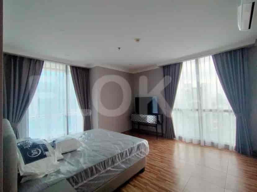 Bedroom featuring a bed, windows, and curtains.