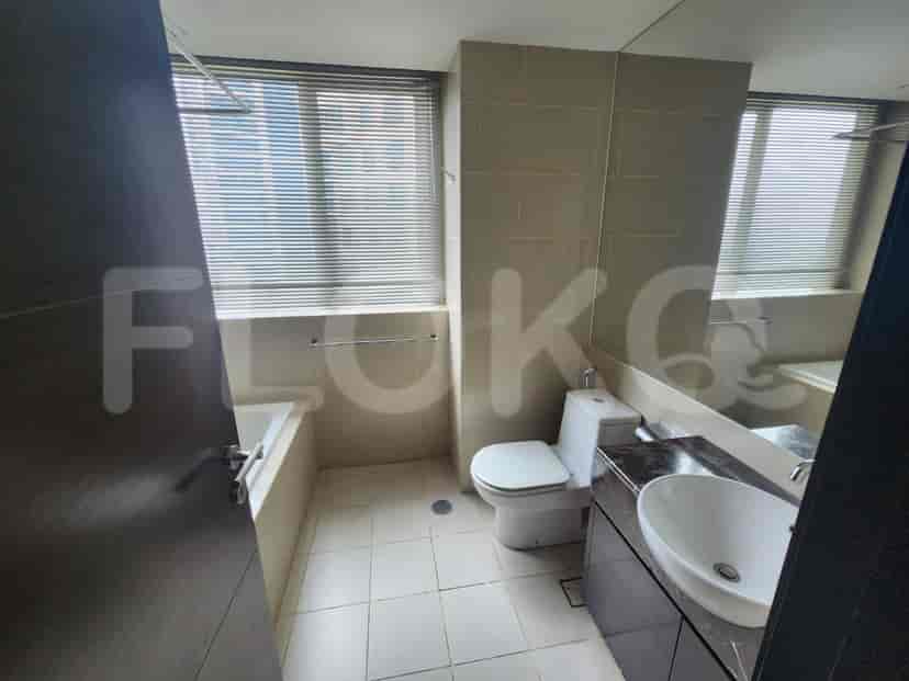 A bathroom with a bathtub, toilet, and a large mirror.