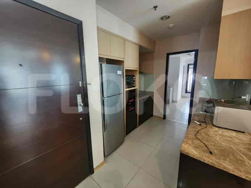 A closed kitchen featuring light-colored cabinetry, stainless steel appliances, and a small breakfast bar.