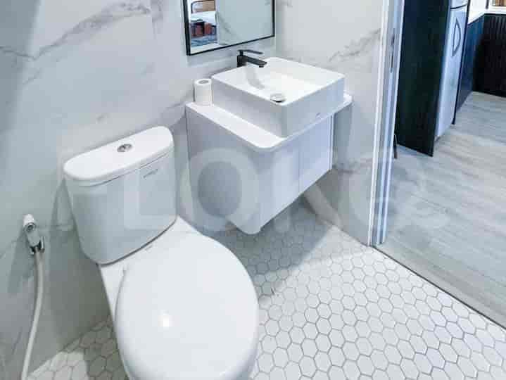 Kamar mandi modern yang menampilkan wastafel gantung dan toilet.