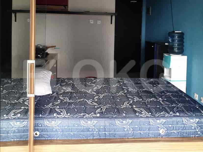 Tampilan kamar tidur, dengan tempat tidur dan dispenser air.