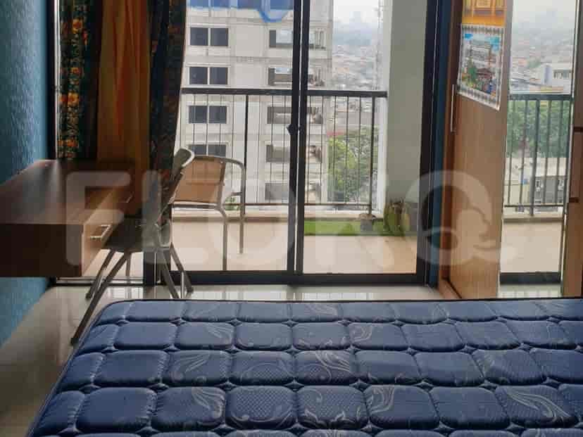 Kamar tidur dengan pemandangan kota, menampilkan tempat tidur, meja, dan balkon.