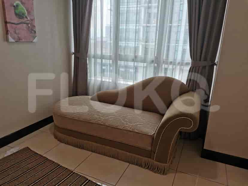 A lounging area with a chaise lounge and a window.