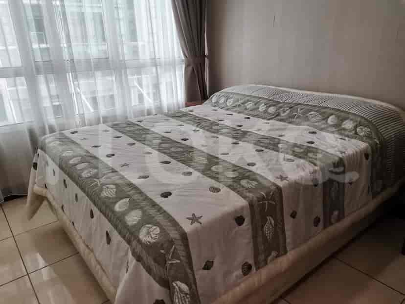 Bedroom with a bed covered with a patterned blanket.
