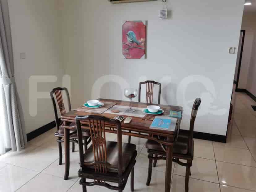Dining area with a wooden table and chairs, decorated with tableware.