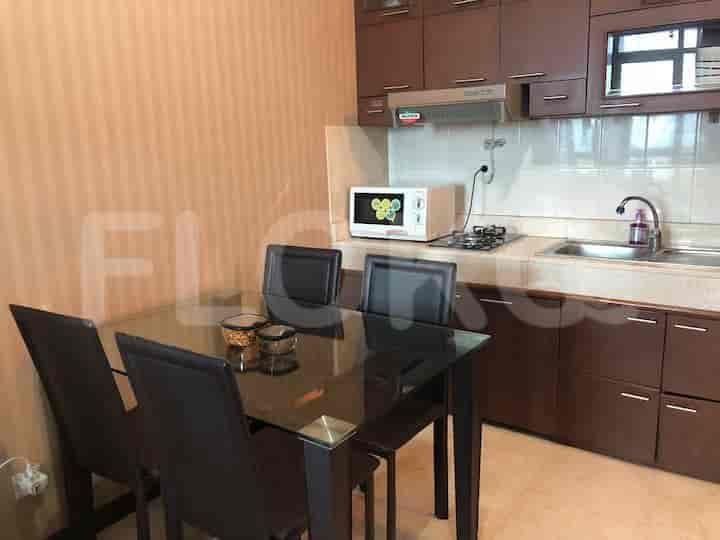 Area ruang makan memiliki meja kaca dan kursi, di sebelah dapur.