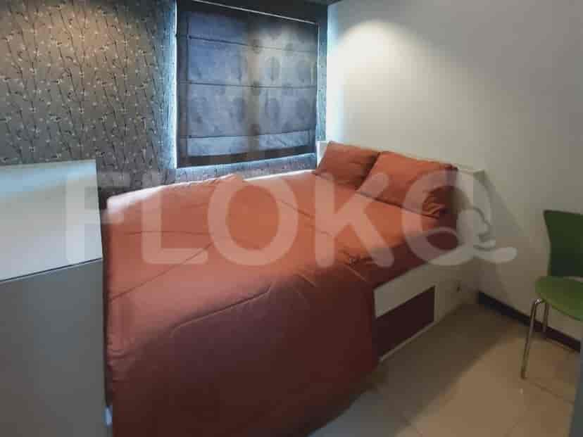 A modern bedroom with a bed and orange bedding.
