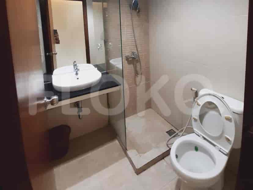 A modern bathroom with a shower, toilet, and sink.