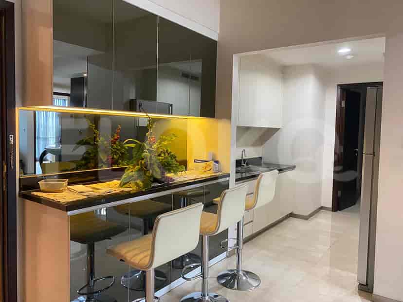 A small kitchenette featuring a breakfast bar, bar stools and white cabinets.