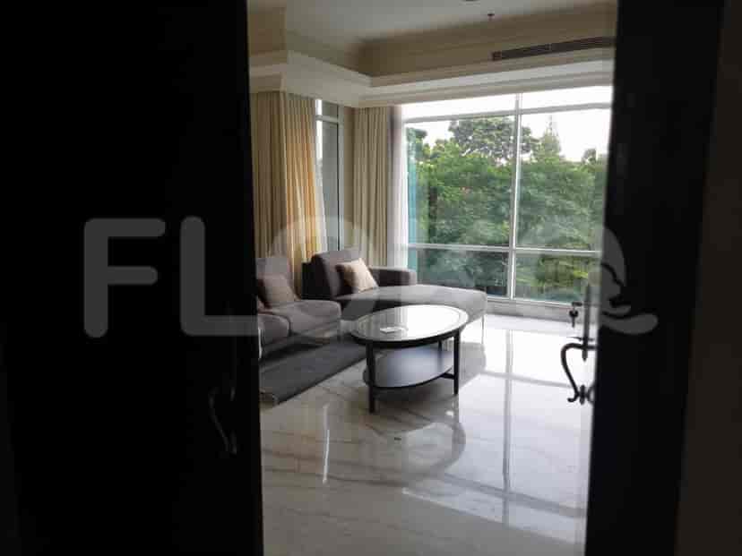 Pemandangan ke ruang tamu yang menampilkan desain modern dengan meja kopi dan sofa dua tempat duduk.