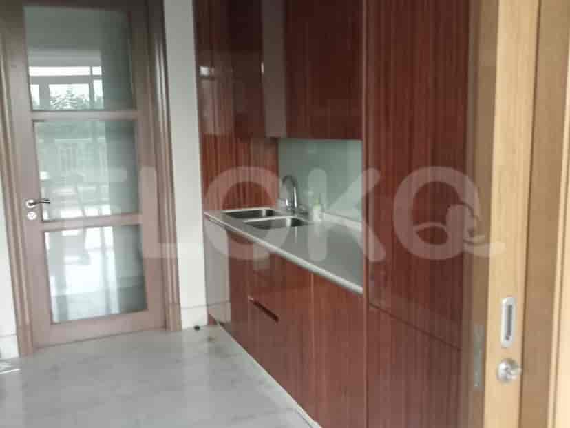 Dapur kecil yang dirancang dengan baik dengan lemari kayu gelap dan bak cuci stainless steel.