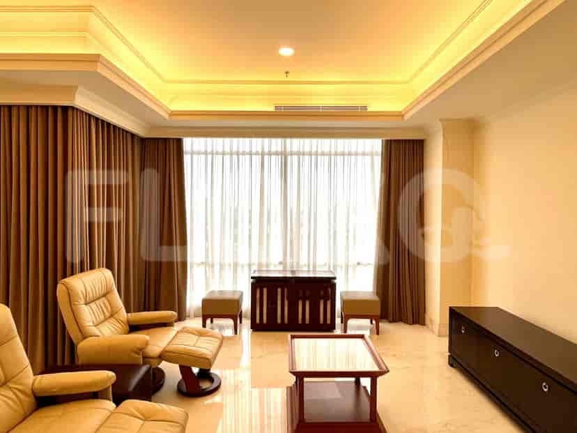 A luxurious living room featuring reclining chairs, elegant curtains, and a coffee table.