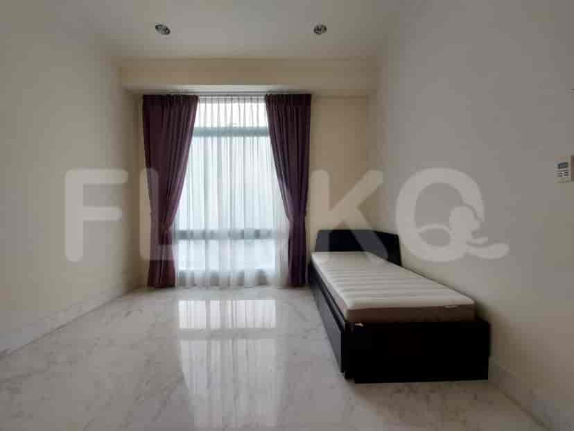 A small bedroom with a single bed and window curtains.