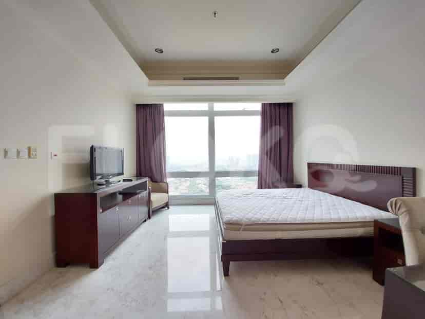 A bedroom featuring a bed, dresser, and a TV.