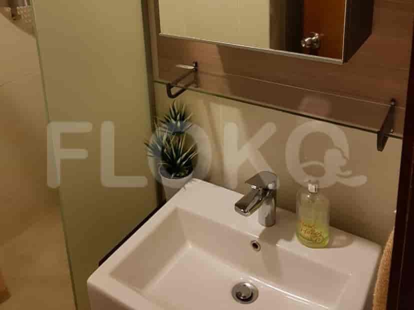 A bathroom with a sink, mirror, and a glass shower enclosure.
