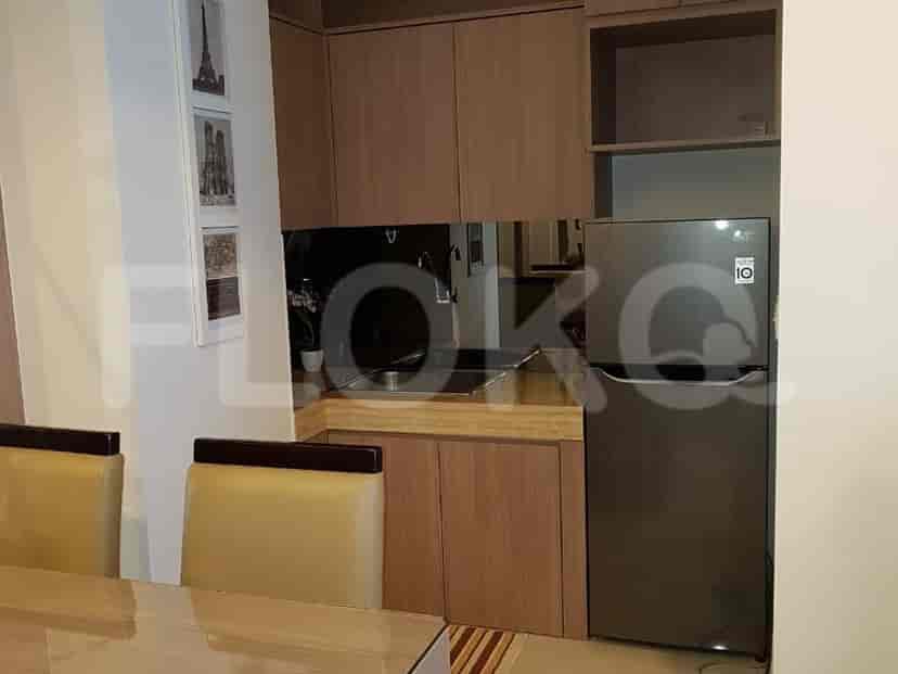 A modern kitchen with wooden cabinetry, a refrigerator, and a sink.