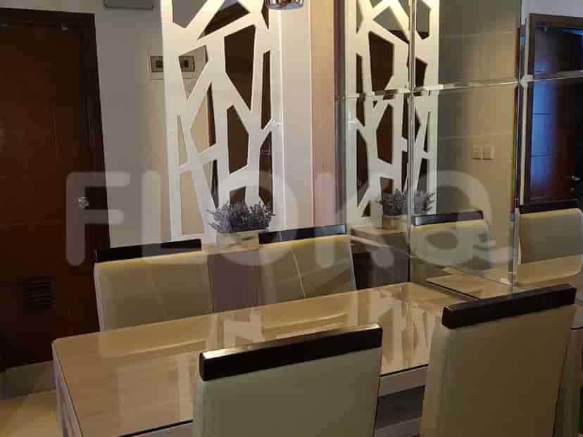 A dining room with a dining table and chairs, and a mirror wall.