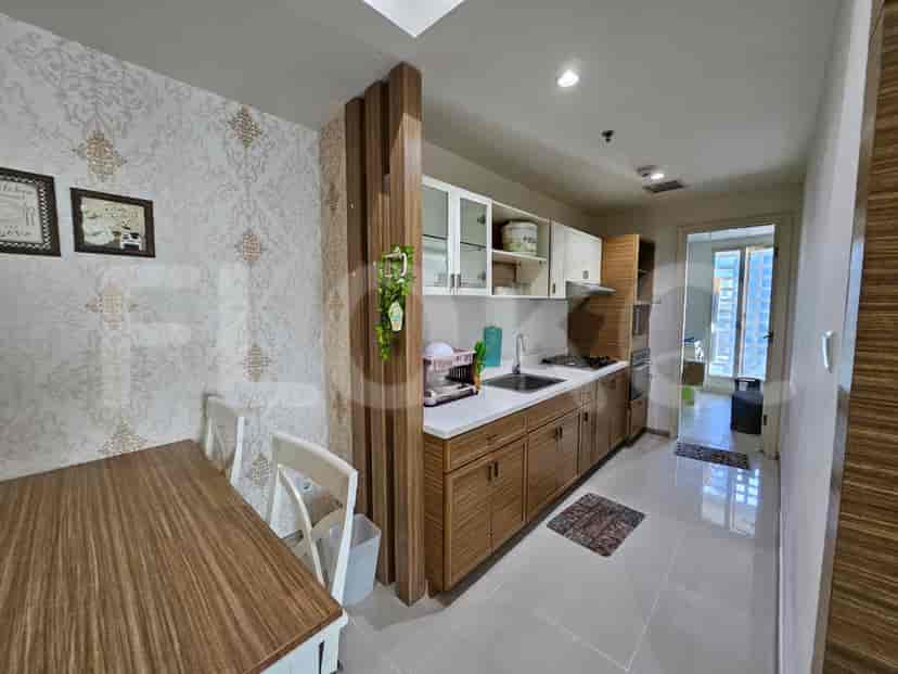 A modern kitchen featuring wooden cabinetry and a dining table.