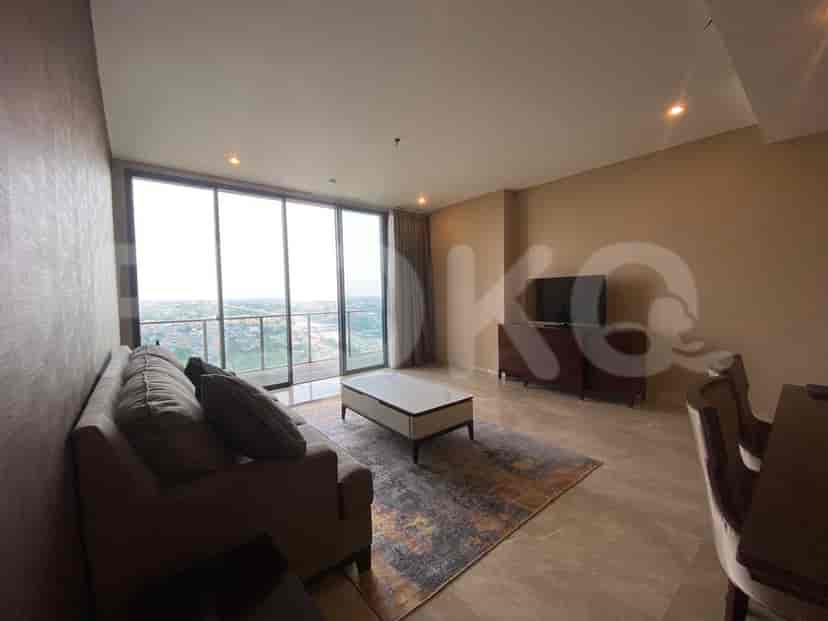 Modern living room with grey sofa, TV, and city view.