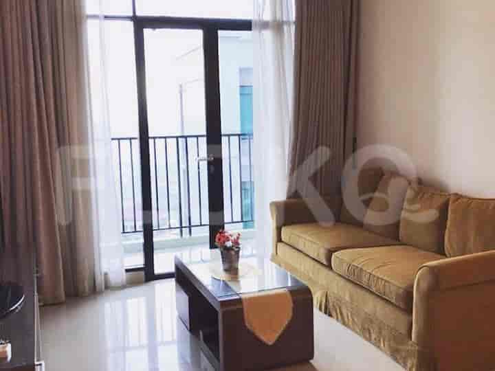 Living room with a sofa, coffee table, and balcony access.