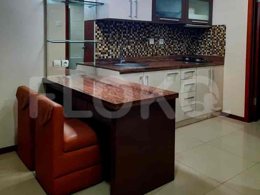Kitchenette with bar seating, cabinets, and a sink.
