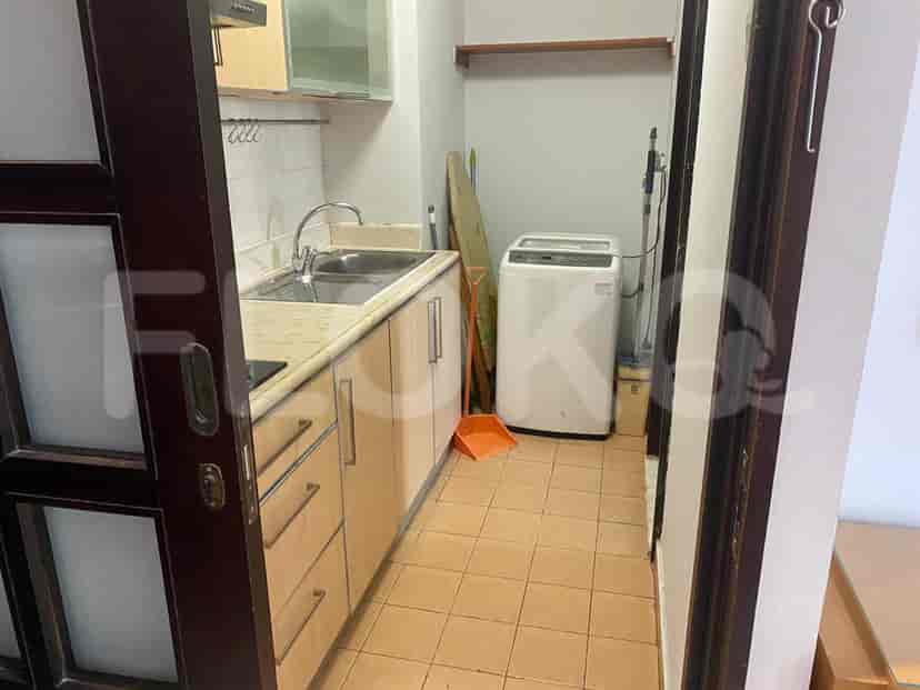 A kitchen with wooden cabinets, a sink, and a washing machine.