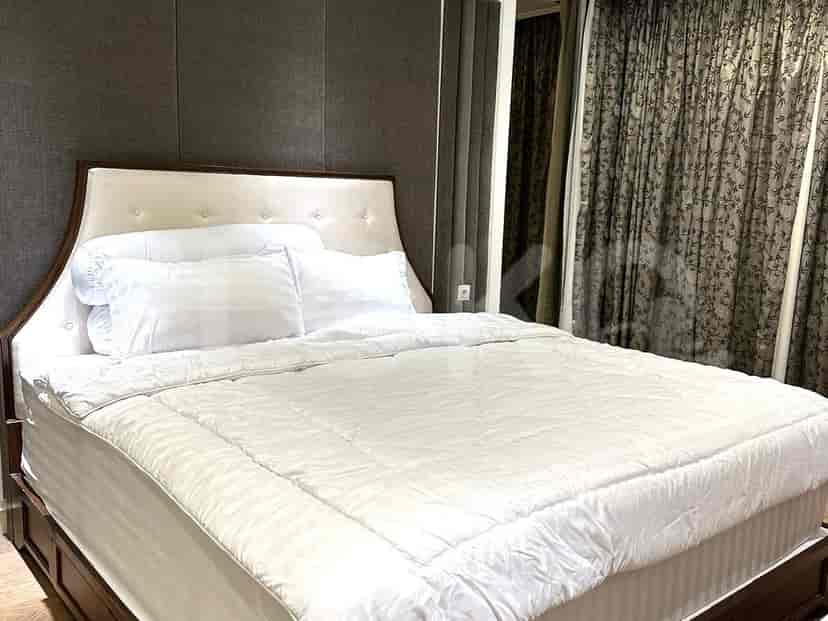 A master bedroom with a large bed, neutral-toned bedding, and dark curtains.
