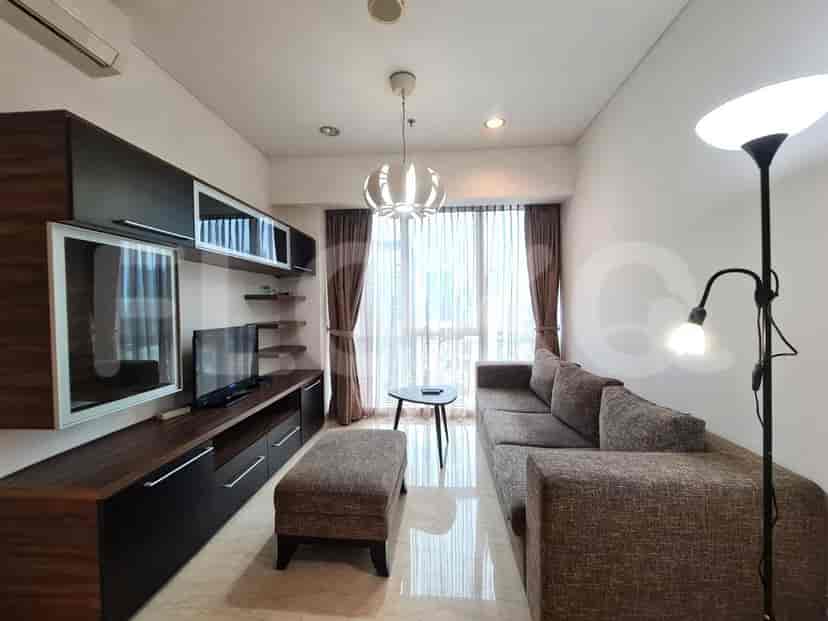 Modern living room with an L-shaped sofa, TV console, and large windows.