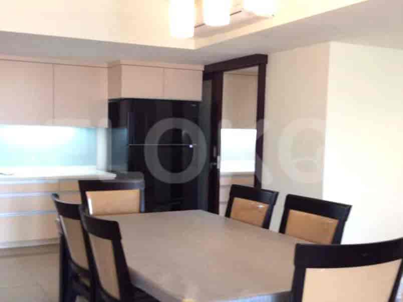 Dining area adjacent to a modern kitchen with built-in cabinets and appliances.