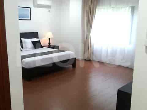 A bedroom featuring a queen-sized bed, bedside table, and a lamp.