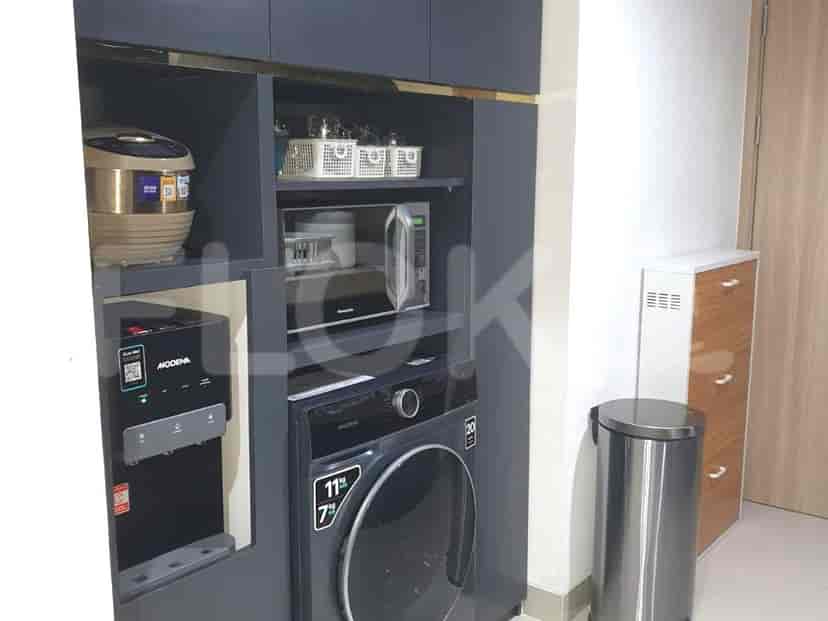 Laundry area with washer, dryer, and kitchen storage.