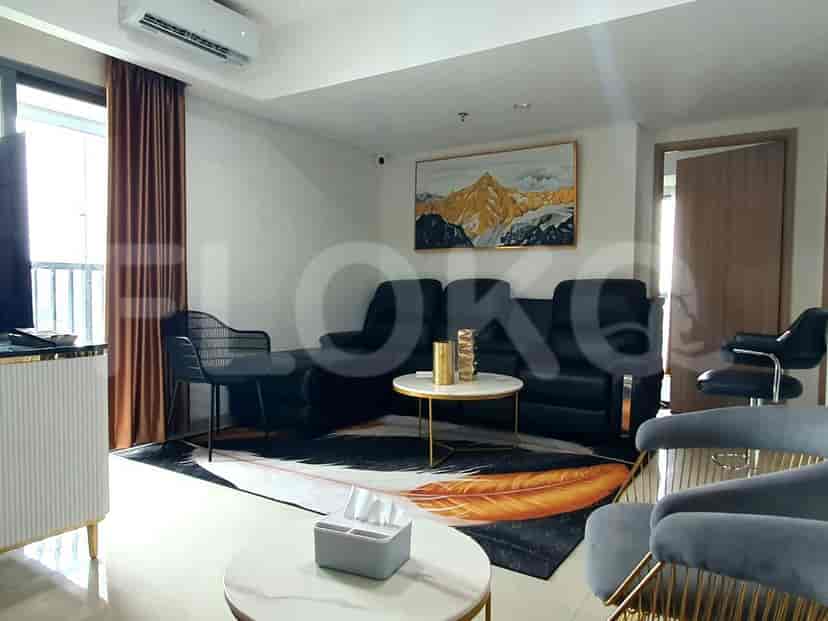 Modern living room with black sofa, artwork, and gold accents.