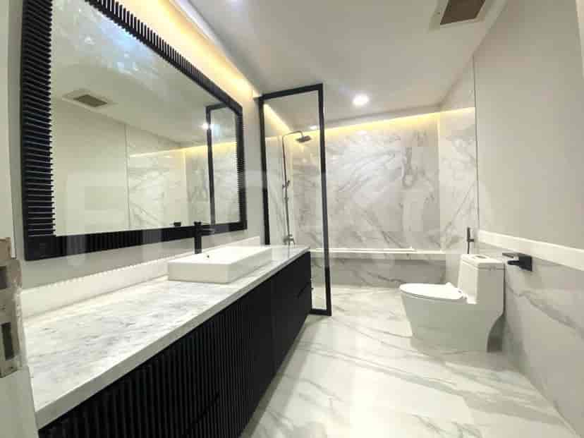 Modern bathroom with a large mirror, a walk-in shower, and a toilet.