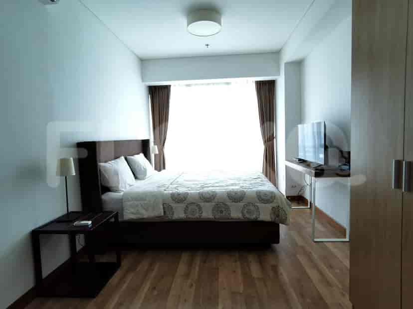 Bedroom with a bed, nightstands, and a television.