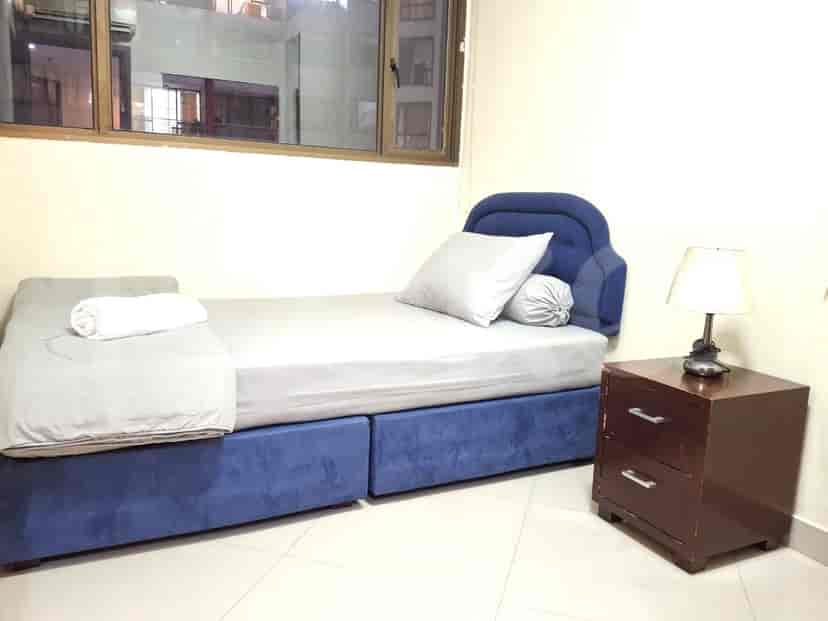A small bedroom with a single bed and a nightstand.