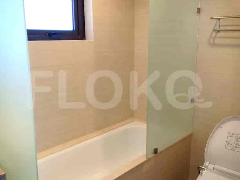 Spacious bathroom with a bathtub, toilet, and window.