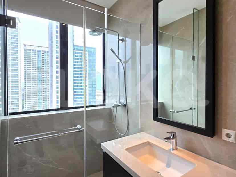 Modern bathroom with a glass shower enclosure, vanity, and a view of the city.