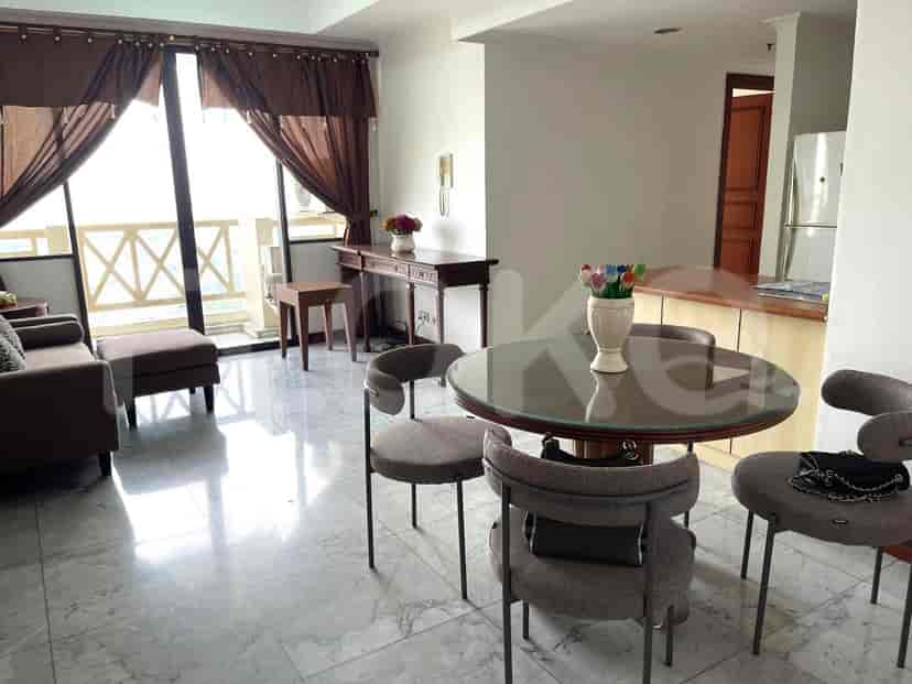 Ruang tamu yang luas dengan lantai marmer, area makan, dan akses balkon.
