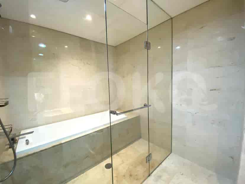 Luxurious bathroom with a bathtub, glass shower, and marble walls.