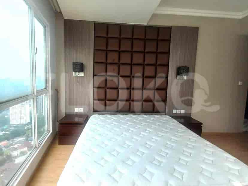 A luxurious bedroom with a bed, nightstands, and a feature headboard.