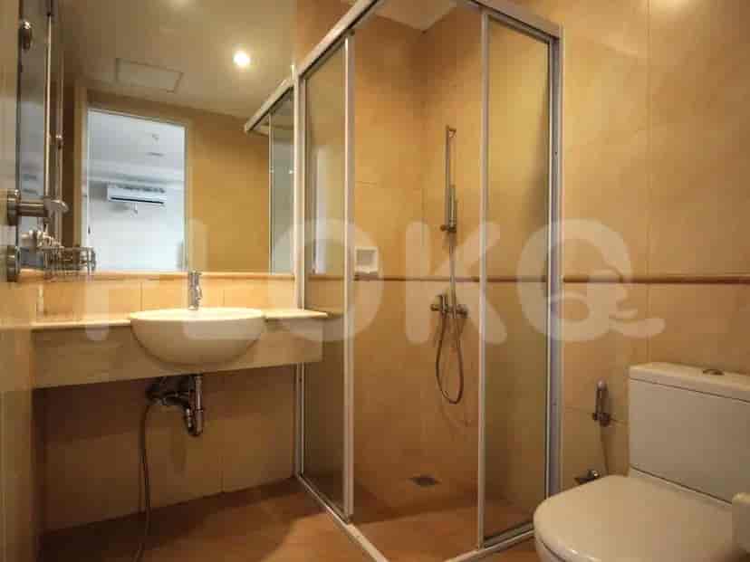 Kamar mandi yang menampilkan pancuran, wastafel, dan toilet dengan desain ubin netral.