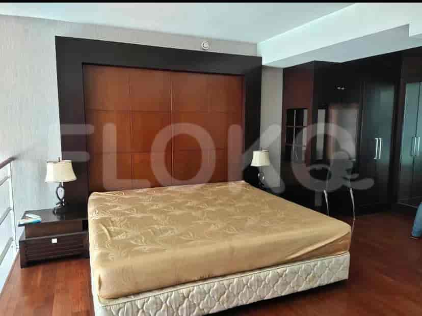 Kamar tidur yang menampilkan tempat tidur dan meja samping tempat tidur.