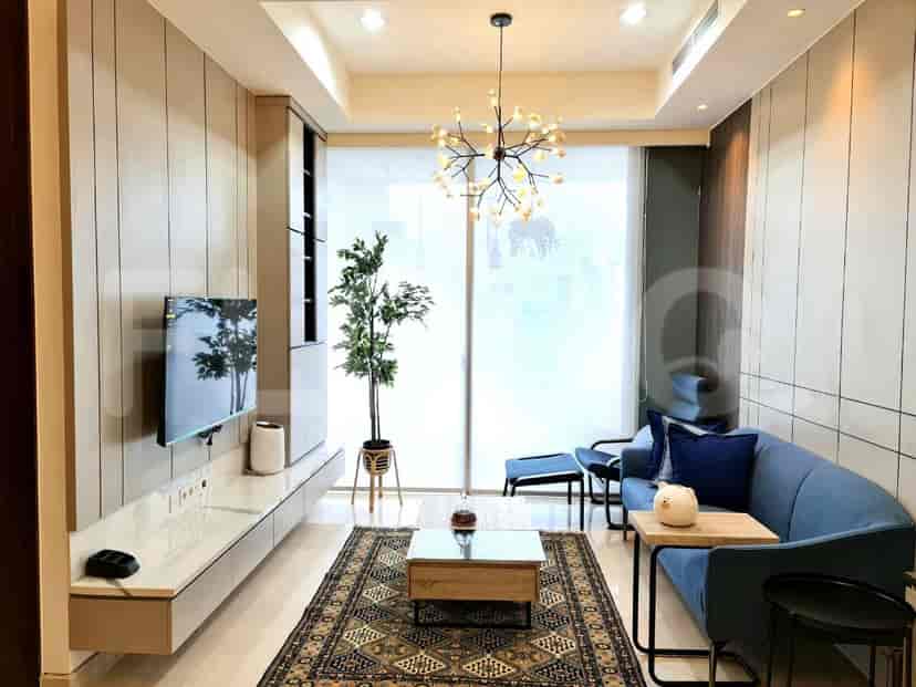 Living room with blue sofa, wall-mounted TV, and a large window.